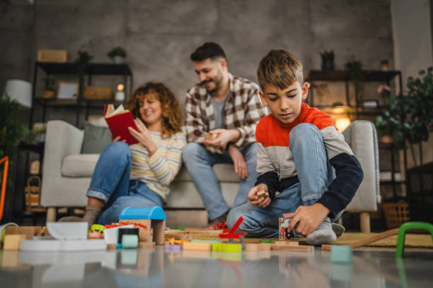 istock boy play with colorful toys while parents sit behind them 2188911709