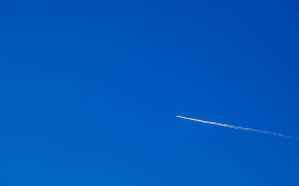 istock An airplane against a blue clear sky with a white trail. 2188914800