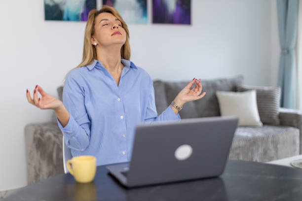 istock Attractive woman meditating and relaxing during work at home 2188916840