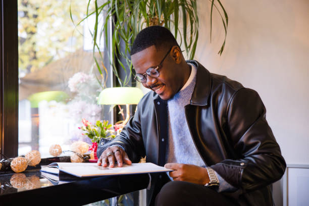 istock Man looking at a book in a cafe 2188920068
