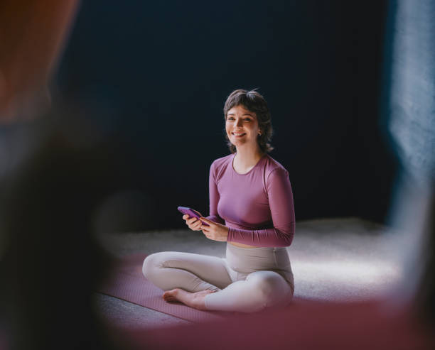 Smiling Woman Practicing Yoga Indoors on a Mat in Bright Attire