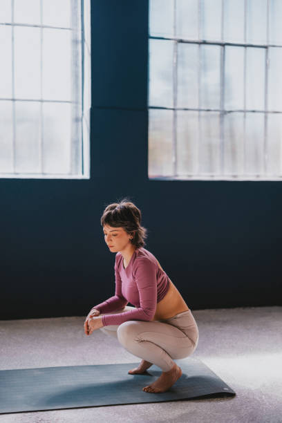 istock Young Woman Practicing Yoga Indoors On A Mat In Sunlit Studio 2188922818