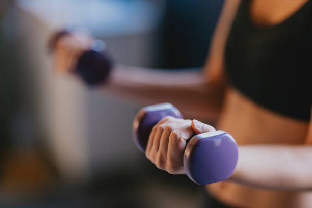 istock Close-Up Of Woman Lifting Dumbbells During Workout Session 2188922843