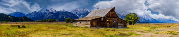 Built in the late 1800s by Thomas Alma and Lucille Moulton, this barn on Mormon Row, stands as a testament to the ingenuity and perseverance of early settlers in the challenging conditions of the Jackson Hole valley. Nestled beneath the towering Teton Range, it remains one of the most photographed barns in the United States, symbolizing the region's rich agricultural history and rugged beauty.  The Thomas Alma and Lucille Moulton barn is in Grand Teton National Park near Jackson, Wyoming, USA.