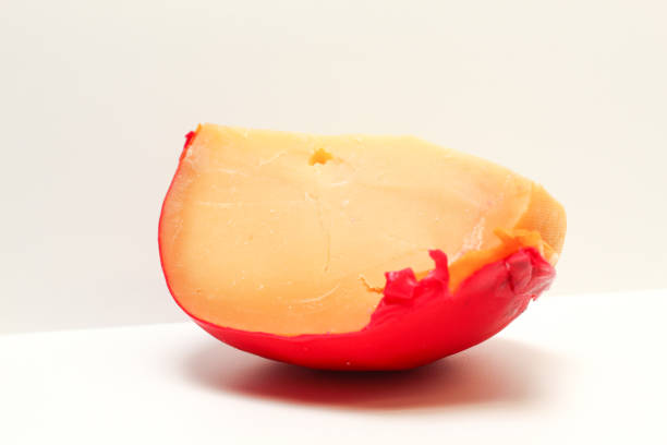 Edam cheese coated with red paraffin wax, isolated on white background