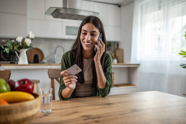 istock Talking on the phone with a credit card in hand 2188929654