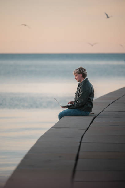 istock Man working on laptop by the ocean 2188931323