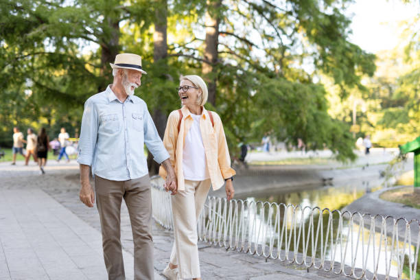 istock Joyful elderly pair walking hand in hand through the park 2188932480