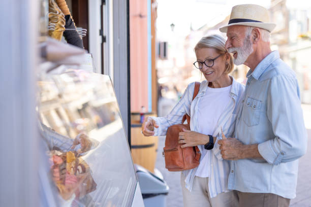 istock Happy elderly couple exploring shop window on sunny day out. 2188932492
