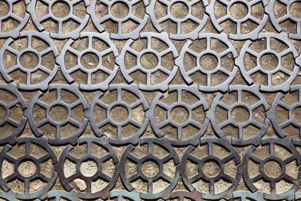 Old gray cast iron grate with on the ground.