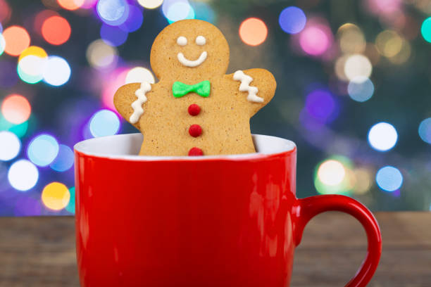 Christmas gingerbread man in hot chocolate on rustic wooden table