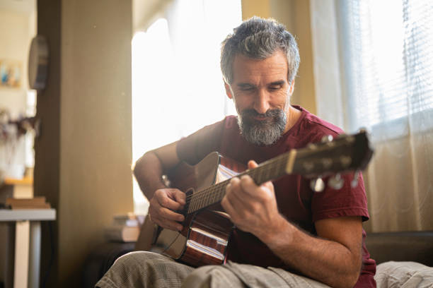 istock Music Therapy. Mature Man Learns to Play the Guitar. 2188934711