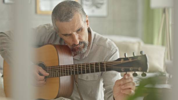 istock Music Therapy. Mature Man Learns to Play the Guitar. 2188934724