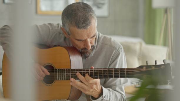 istock Music Therapy. Mature Man Learns to Play the Guitar. 2188934728