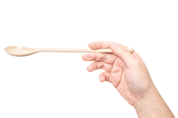 istock Female hand holding a brown plastic spoon isolated on white background. 2188943002