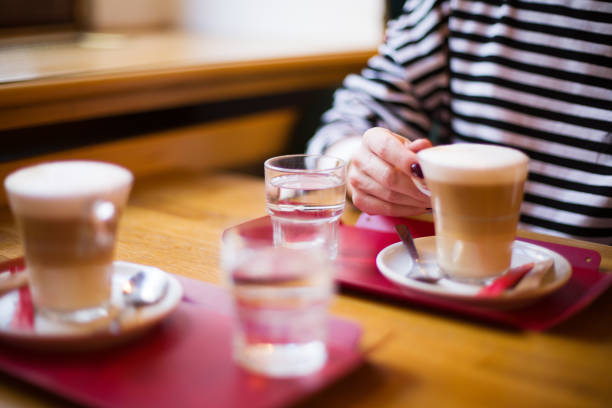 Two Lattes on Table with Woman Hand. High quality photo