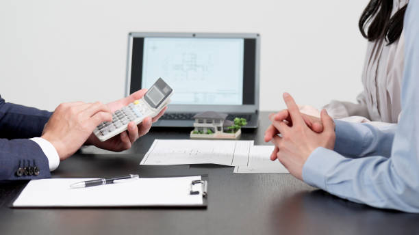 businessman calculating real estate quote - unifamiliares promocion fotografías e imágenes de stock