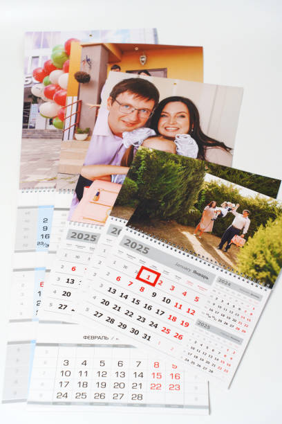 istock tear-off calendars with family photos on a white table. 2188950901