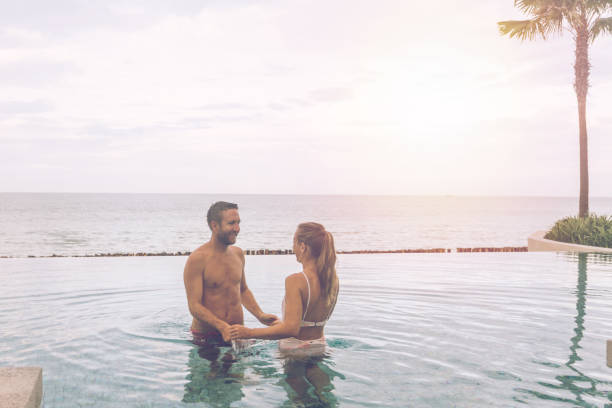 istock Couple Enjoying Leisure Time in Infinity Pool by the Ocean 2188951149