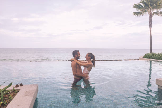 istock Romantic Couple Embracing in Infinity Pool by Ocean 2188951162