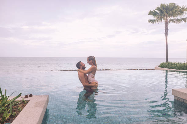 istock Romantic Couple Embracing in Infinity Pool by Ocean 2188951172