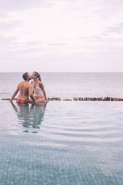 istock Couple Kissing In Infinity Pool Overlooking Ocean 2188951704