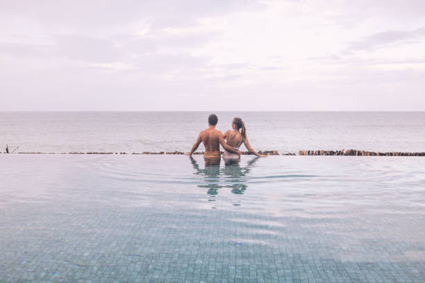 istock Couple Embracing in Infinity Pool Overlooking Ocean 2188951713