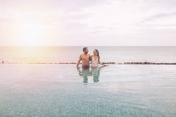 istock Couple Embracing in Infinity Pool Overlooking Ocean 2188951722