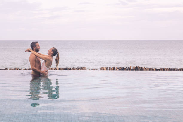 istock Couple Embracing in Infinity Pool Overlooking Ocean 2188951726