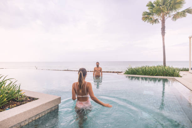 istock Couple Relaxing in Infinity Pool Overlooking Ocean 2188951744
