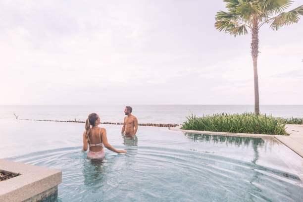 istock Couple Relaxing in Infinity Pool Overlooking Ocean 2188951747