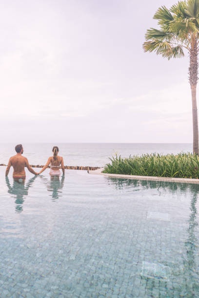 istock Couple Relaxing in Infinity Pool Overlooking Ocean 2188951754