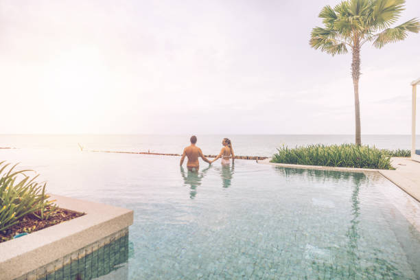 istock Couple Relaxing in Infinity Pool Overlooking Ocean 2188951757