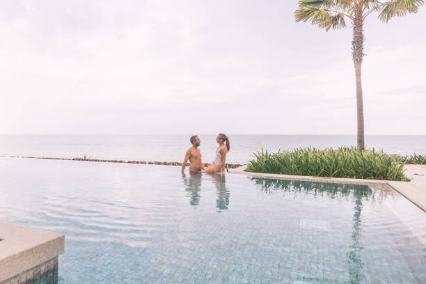 istock Couple Relaxing by Infinity Pool with Ocean View 2188951781