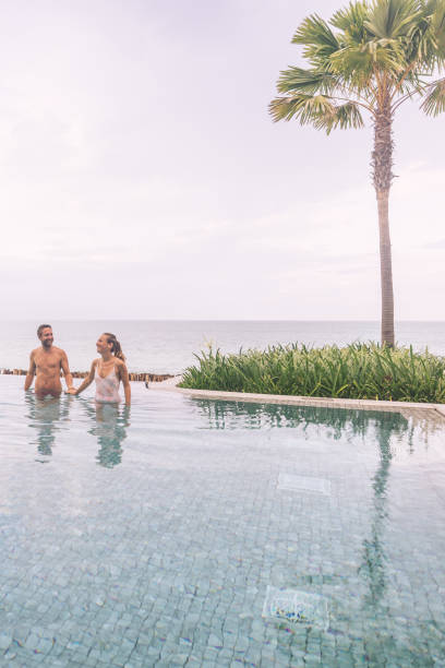 istock Couple Enjoying a Relaxing Dip in Infinity Pool by the Ocean 2188951783