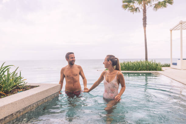 istock Couple Enjoying Poolside Retreat by the Ocean 2188951791