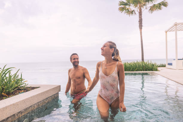 istock Couple Enjoying Poolside Retreat by the Ocean 2188951793