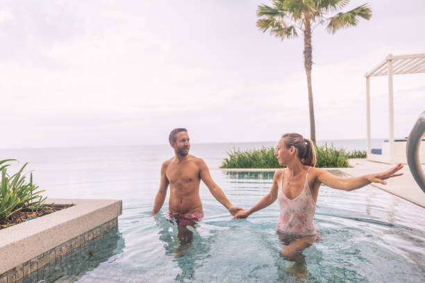 istock Couple Enjoying Poolside Retreat by the Ocean 2188951816