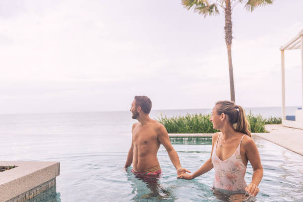 istock Couple Enjoying Poolside Retreat by the Ocean 2188951817