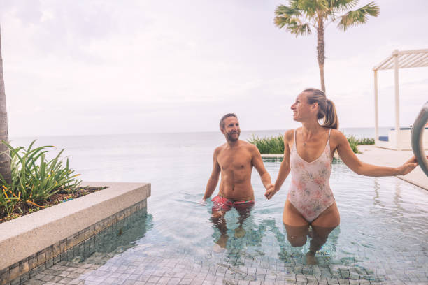 istock Couple Enjoying Poolside Retreat by the Ocean 2188951822