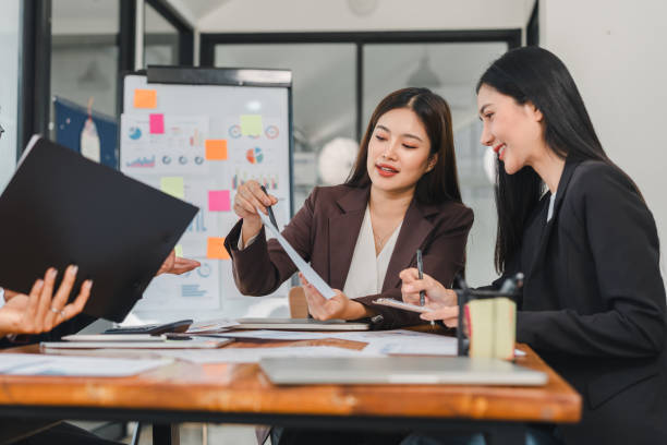 istock Efficient business meeting with women discussing project details, analyzing documents, and collaborating in modern office space 2188951951