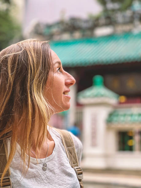 istock Smiling Woman Exploring Historical Temple Background 2188954368