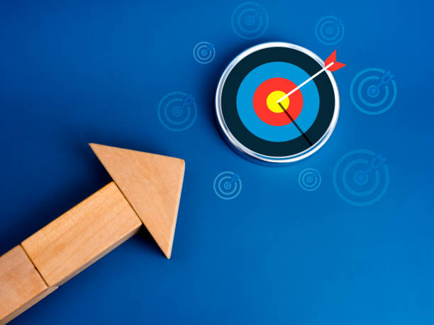 istock Choosing the right goal, leadership, business growth plan, objective trends, success aiming concept. The modern big new target icon will hit by big arrowhead, wooden blocks as arrow, blue background. 2188960882
