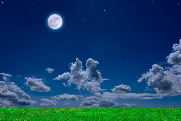 The full moon glows softly over open farmland beneath a pastel-colored sky. Gentle hues of pink and blue merge across the horizon, creating a serene and tranquil evening scene.