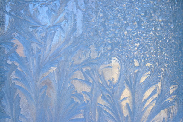 Frost pattern on a frozen window at winter. Natural background, texture