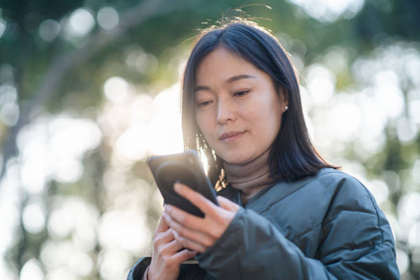 istock asian female holding smart phone 2188964834