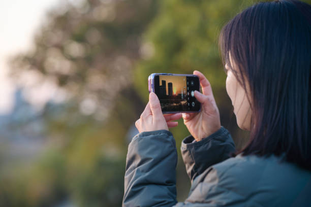 istock asian female take picture with smart phone during sunset 2188965277