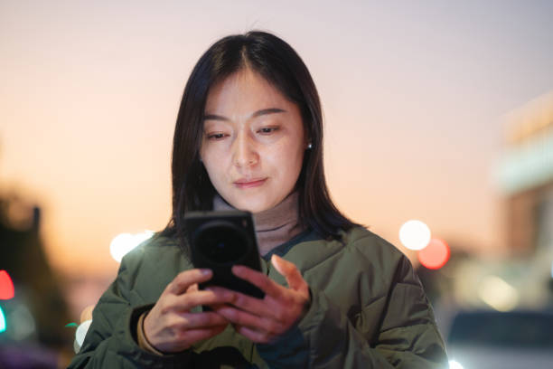 istock asian female using smart phone outdoor 2188965302