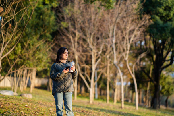 istock asian female using smart phone outdoor 2188965551
