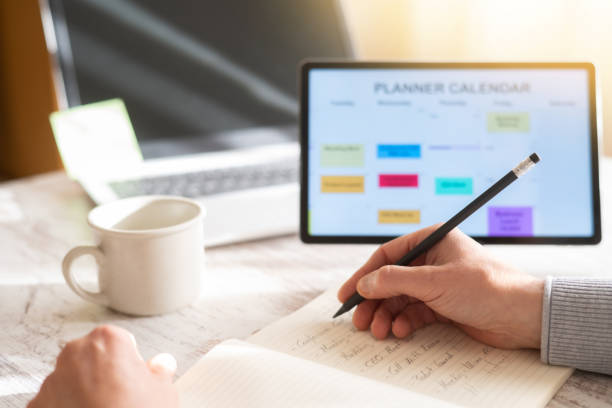 istock Entrepreneur Planning Client Appointments, Business Meetings And Weekly Schedule In Digital Agenda Using Tablet. Business Professional Managing Time And Professional Events. 2188966372